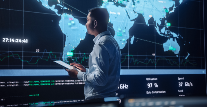 Project Manager using a tablet walk to a big screen with Global Map.