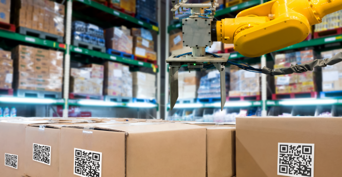 Automation robot arm machine in a warehouse classifying a group of boxes using QR code.
